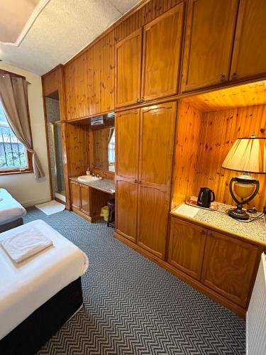 a room with a bed and a desk with a lamp at The Egerton Arms Hotel Salford in Manchester