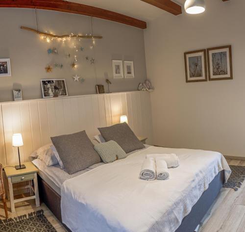 a bedroom with a large bed with towels on it at Mustármag Vendégház in Noszvaj