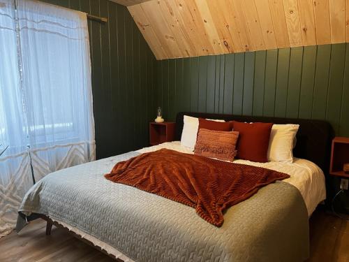 a bedroom with a bed with a blanket on it at Le Petit chalet au Lac Schryer in Lac-Simon