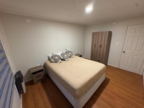 ein Schlafzimmer mit einem Bett mit zwei Kissen darauf in der Unterkunft Aur House in Puerto Natales