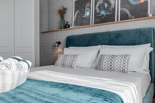 Schlafzimmer mit einem Bett mit blauem Kopfteil und Kissen in der Unterkunft Vetro - Sweet Dreams in Florence in Florenz