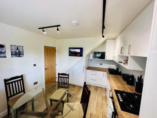 a kitchen with white cabinets and a table and chairs at 3 bedroom Brookwood Road apartment in Southampton