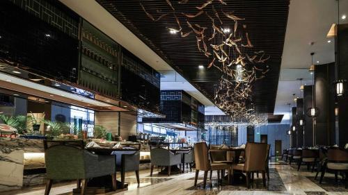 a restaurant with tables and chairs and a chandelier at Lancaster Legacy Hotel & Apartments in Ho Chi Minh City