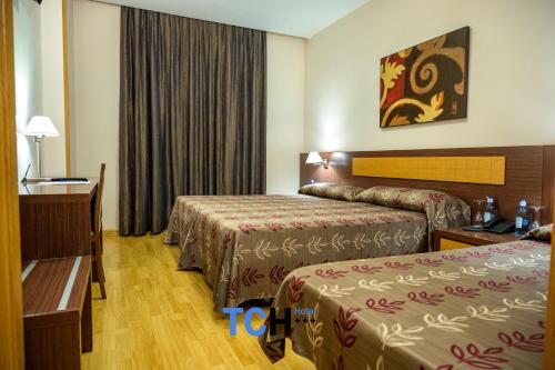 a hotel room with two beds and a table at TCH Hotel in Lorquí