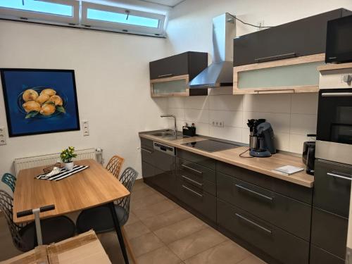 a kitchen with a wooden table and a dining room at Renatus Apartments in Eschau
