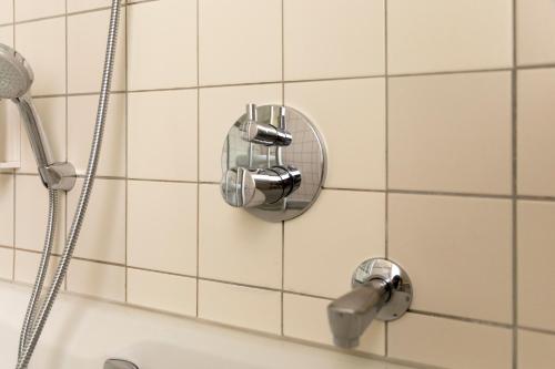 eine Duschkabine mit einem Duschkopf und einer Badewanne in der Unterkunft Schlosshotel Ahaus in Ahaus