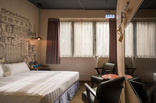 a hotel room with a bed and two chairs at Cho Hotel in Taipei