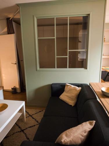 a living room with a black couch and a window at Jplc in Granville