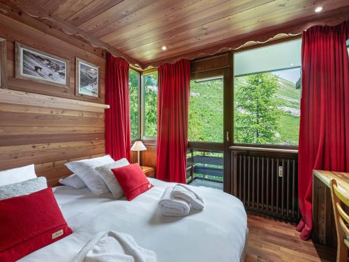 a bedroom with a large bed with red curtains at Grand appartement à Val-d'Isère : 4 pièces, 95m², 7 pers, balcons, parking, exposé Sud-Est - FR-1-567-4 in Val dʼIsère