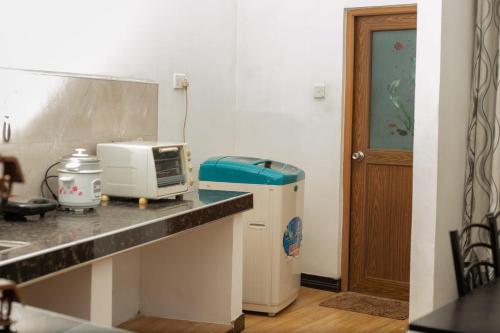 een keuken met een aanrecht met een magnetron en een koelkast bij S & S Homestay in Walliwala East