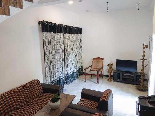 een woonkamer met 2 banken en een televisie bij S & S Homestay in Walliwala East