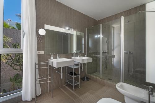 a bathroom with two sinks and a shower at Villa Playa del Duque in Adeje