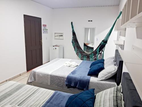 a bedroom with two beds and a hammock at Hospedagem Aconchego Do Lar in Barreirinhas
