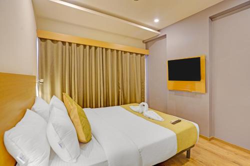 1 dormitorio con 1 cama blanca grande y TV en The Byke Landmark - Near C21 Mall, en Indore