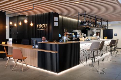 a bar in a restaurant with people sitting at it at voco Bilbao - City by IHG in Bilbao