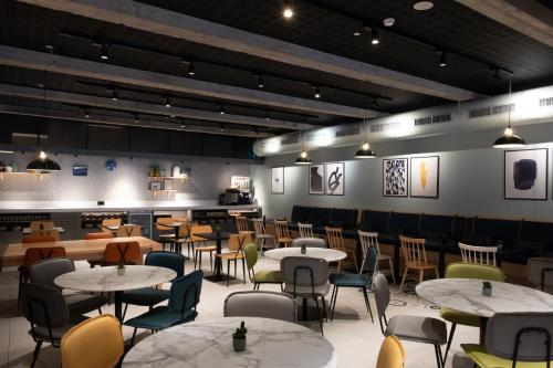 a restaurant with tables and chairs in a room at voco Bilbao - City by IHG in Bilbao