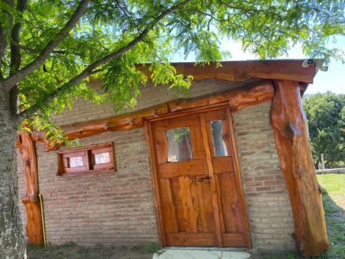 a small brick building with a large wooden door at cabaña Mirador in Bialet Massé