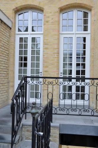 a building with two windows and a black railing at B&B 't Withuis in Diksmuide