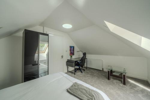 una camera da letto con un letto, una sedia e una scrivania di Modern 4-Bed Retreat in Prestwich, Perfect for Weekend Getaways a Manchester