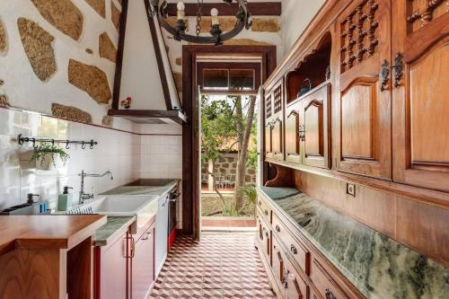 a kitchen with wooden cabinets and a sink at Foz Townhouse- Sea, Garden & Garage in Porto