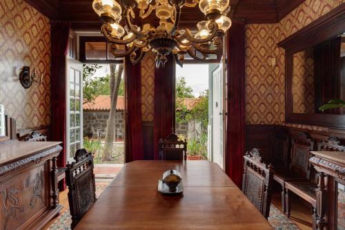 a dining room with a large wooden table and a chandelier at Foz Townhouse- Sea, Garden & Garage in Porto