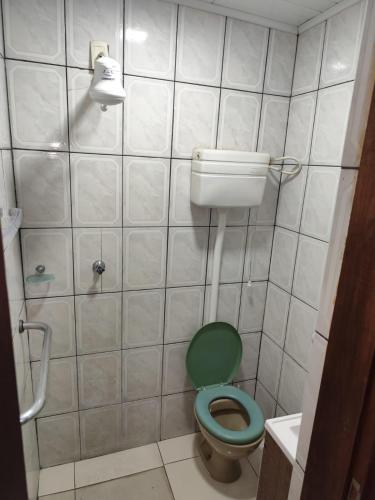 a bathroom with a green toilet and a sink at Casa térrea no centro in Vitória da Conquista