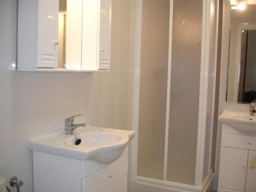 een witte badkamer met een wastafel en een spiegel bij Rinconada Real - Zand Properties in Benidorm