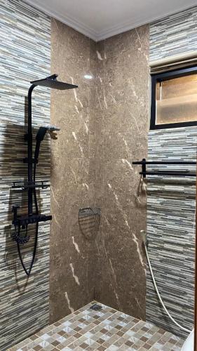 a shower in a bathroom with a stone wall at Villa umaya 3 Bedroom Privat Pool in Paragajen