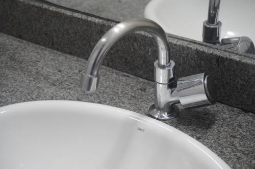 a bathroom sink with a white sink at Hotel Premium Uruçuí in Uruçuí
