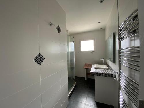 un piccolo bagno con lavandino e doccia di Maison paisible a Gujan-Mestras