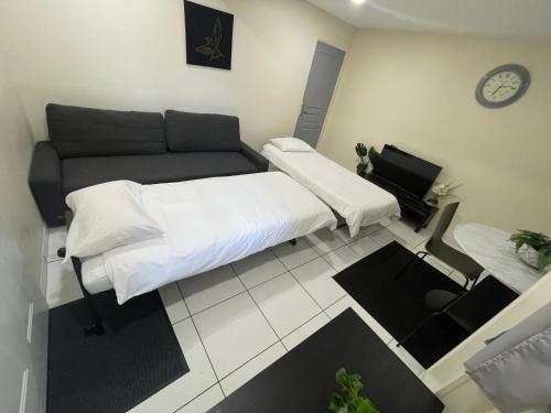 a living room with a bed and a couch at Résidence Chene- 15 MN de Paris et 05 MN d'Orly Aéroport in Viry-Châtillon