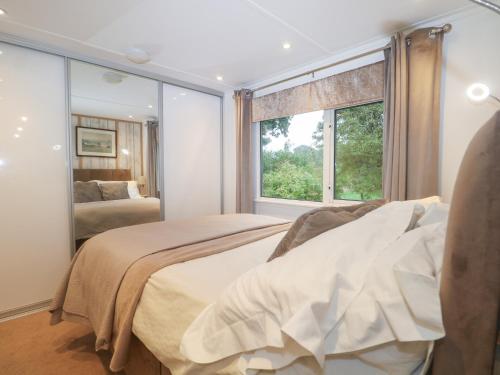 a bedroom with two beds and a window at Orchard Lodge in Haywards Heath