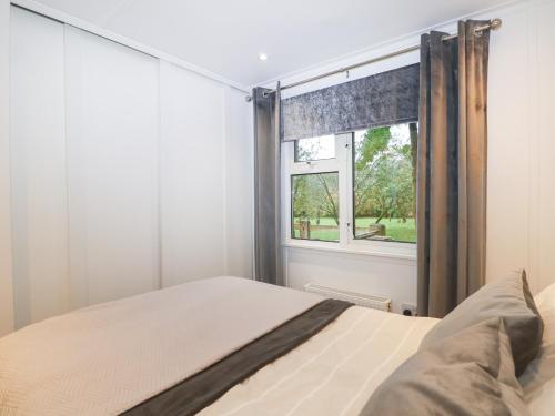 a bedroom with a bed and a window at Orchard Lodge in Haywards Heath