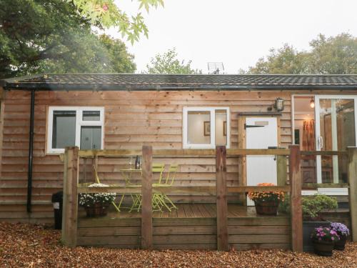 a log cabin with a wooden fence at Orchard Lodge in Haywards Heath