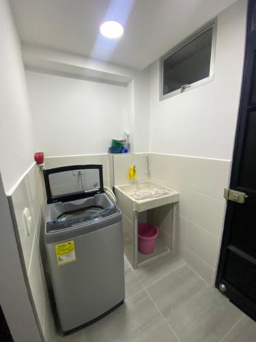 a small bathroom with a trash can and a sink at Apartamento nevado reserva de curinca in Santa Marta