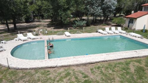 a woman is standing in a swimming pool at Complejo Sol Mediterraneo in Cosquín