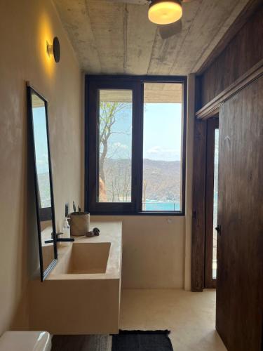 a bathroom with a sink and a large window at Villa Xololo Luxury Villa, La Boquilla Beach in Arroyo Cruz