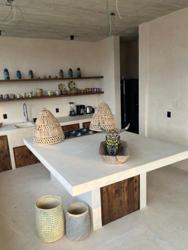 a kitchen with a counter with bowls and stools at Villa Xololo Luxury Villa, La Boquilla Beach in Arroyo Cruz