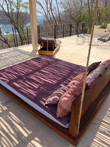 a bed with pillows on a porch at Villa Xololo Luxury Villa, La Boquilla Beach in Arroyo Cruz