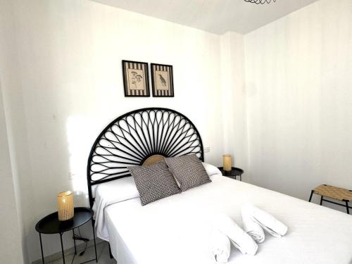 Un dormitorio con una gran cama blanca con dos almohadas. en Sibs Sanlucar Bajamar - Bright & Central, en Sanlúcar de Barrameda