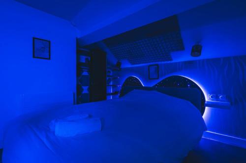 a dark room with a bed with a blue light at Loft Spa Sauna Hammam Hydromassage in Reims