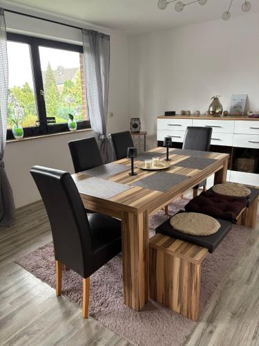 a wooden table and chairs in a room with a kitchen at Ferienwohnung Werne in Werne an der Lippe