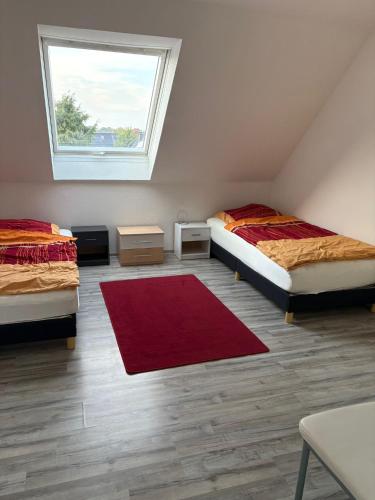 a room with two beds and a red rug at Ferienwohnung Werne in Werne an der Lippe