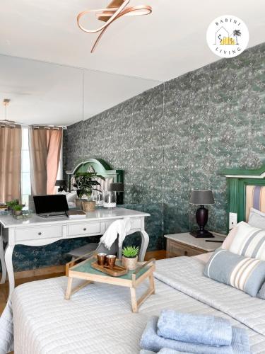a bedroom with two beds and a desk with a laptop at Atico del Sol by Babiniliving in Puerto del Rosario
