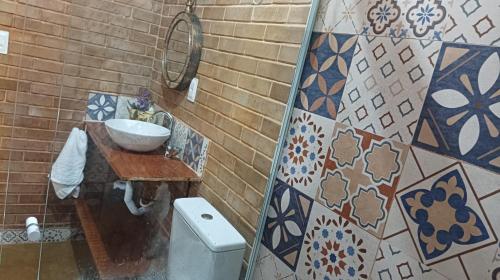 a bathroom with a sink and a toilet at Casa Sustentável de Terra! in Lençóis