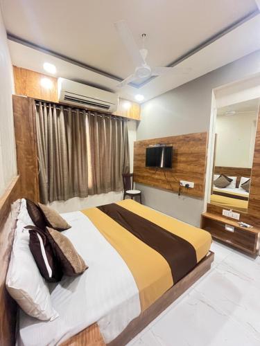 a bedroom with a large bed and a mirror at Hotel Bansuri I opposite shreenathji temple 80mtr away 966o9o1oo6 in Nāthdwāra