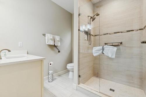 Stylish & sun-filled retreat with large patio & fireplace - near beaches & golf في فرناندينا بيتش: حمام مع دش ومغسلة ومرحاض