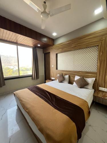 a bedroom with a large bed and a large window at Hotel Bansuri I opposite shreenathji temple 80mtr away 966o9o1oo6 in Nāthdwāra