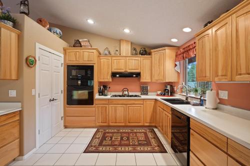a kitchen with wooden cabinets and a rug at 16 Jillian home in Three Rivers