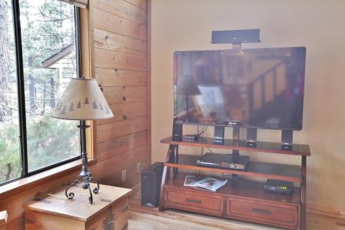 a living room with a flat screen tv and a lamp at Pet Friendly 8 Leisure Home in Sunriver